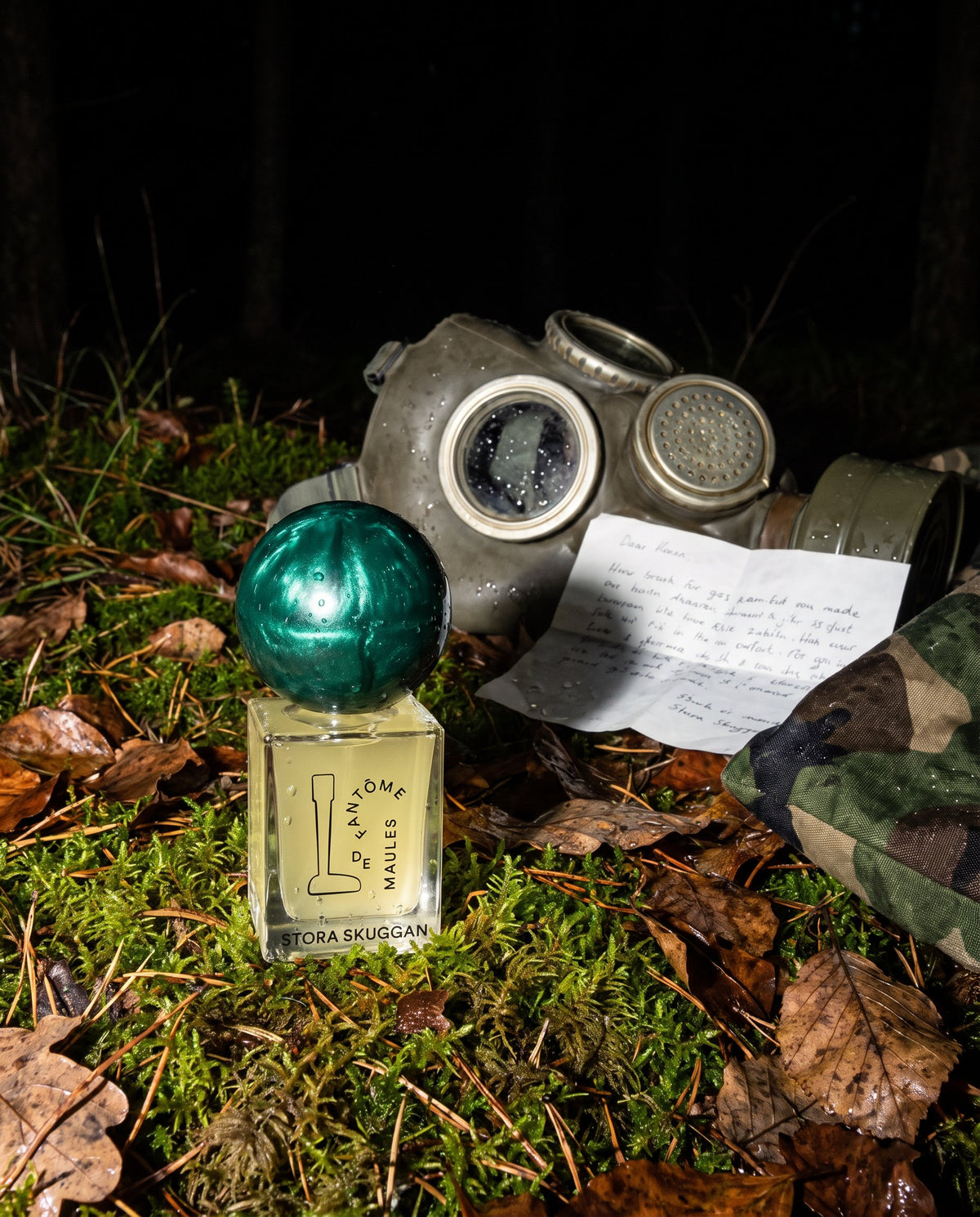 Fantôme de Maules de Stora Skuggan sobre musgo en un bosque de noche junto a una máscara de gas